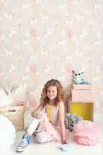 Soft pink background with unicorns, blossoms and trees makes for a whimsical unicorn pink wallpaper design.